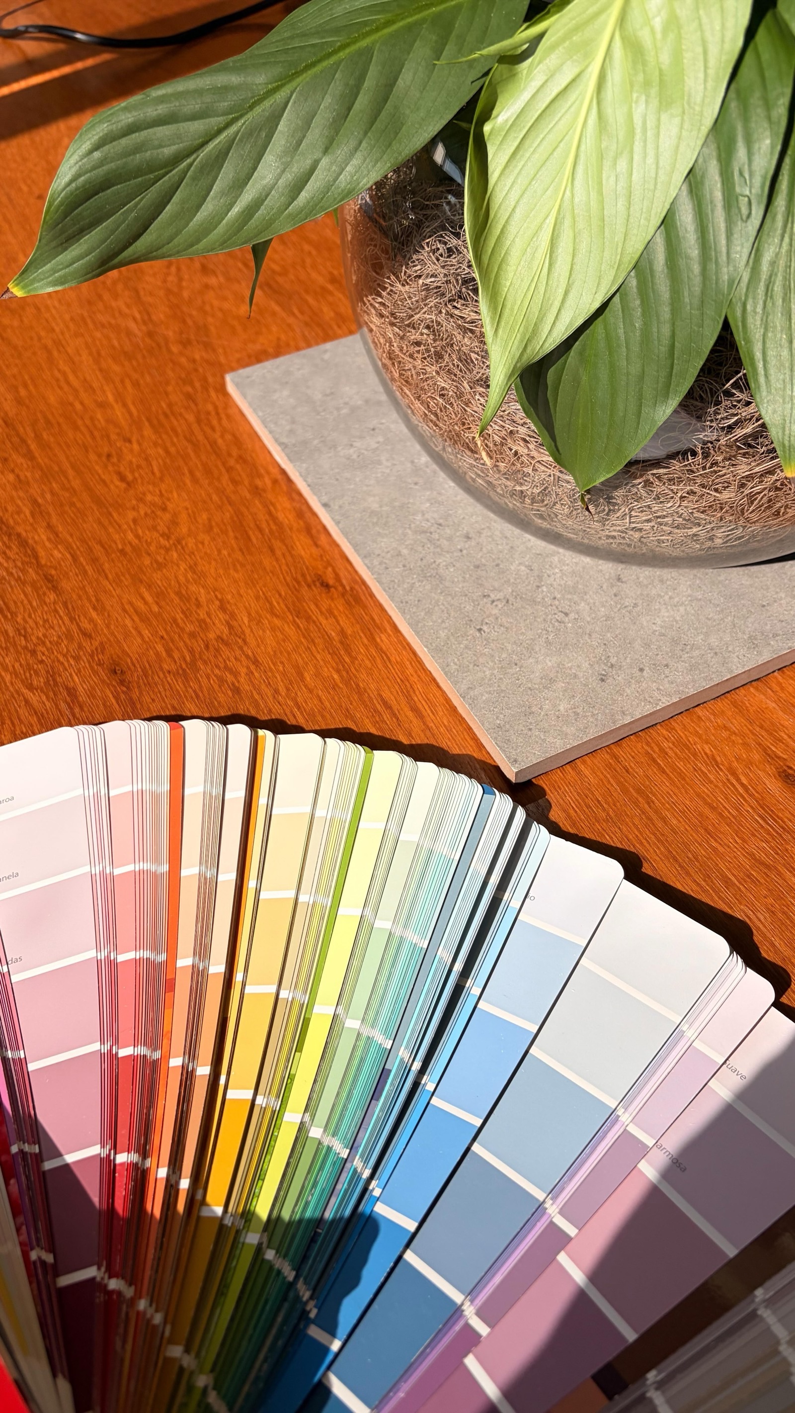 Cartela de cores e amostra de porcelanato sobre mesa de madeira durante a seleção de acabamentos